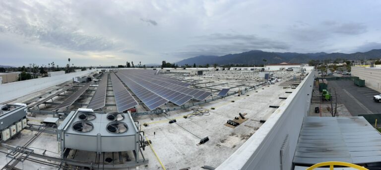 Long, panoramic view of a large commercial solar installation.
