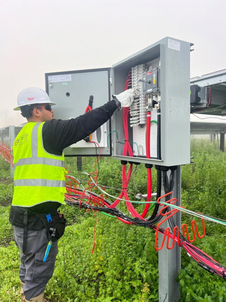 Electrician working inside an electrical panel or junction box at Joint Force Los Alamitos.